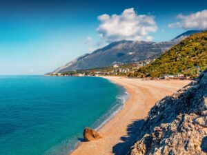 Dhërmi beach on the Albanian Riviera with clear blue-green water and pebble shore